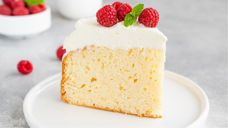 slice of white cake with white icing and raspberries on top