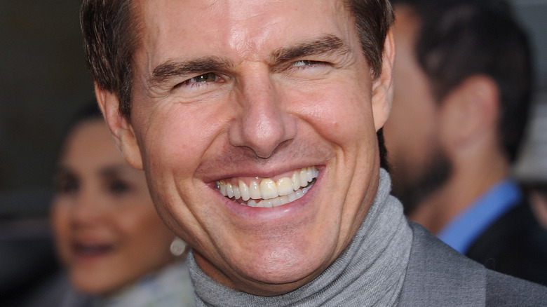 Tom Cruise with wide smile and turtleneck at a premiere