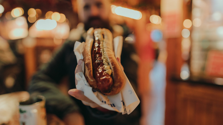 man holding hot dog