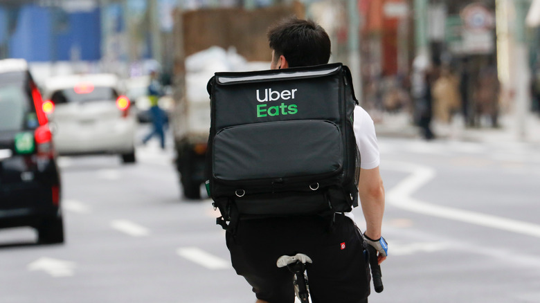 Uber Eats delivery person on bike with black bag