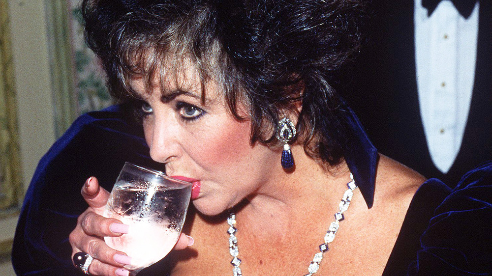 Elizabeth Taylor drinking something from a glass