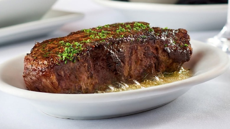 Cooked steak on plate garnished with herbs