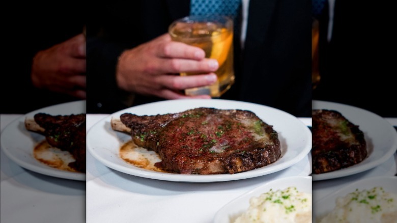 Ruth's Chris bone-in ribeye on white oval plate