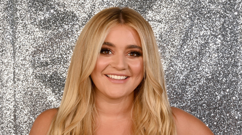 Tilly Ramsay posing for a photo with a glittery silver backdrop