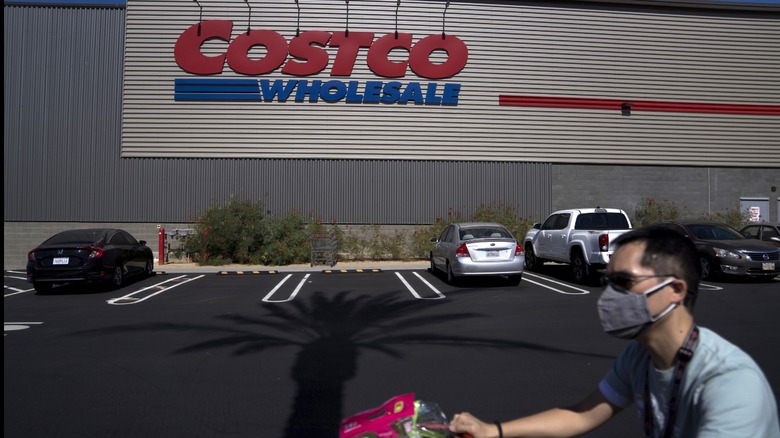 Customer pushing a cart in front of a Costco store