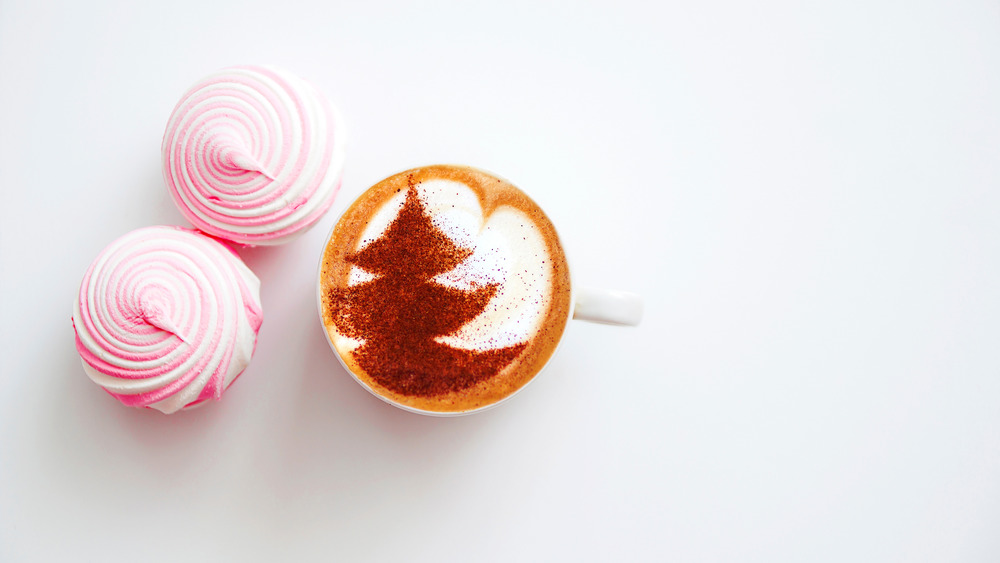 Coffee with milk and cinnamon on top with cupcakes