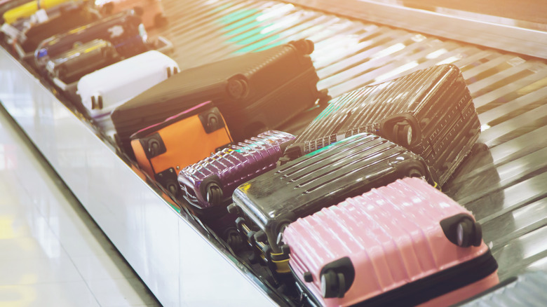 An airport baggage carousel with suitcases