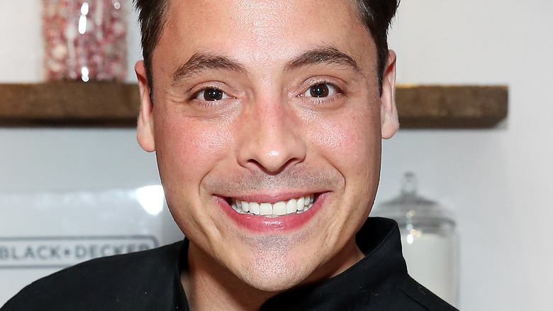 Jeff Mauro smiling in chef's jacket