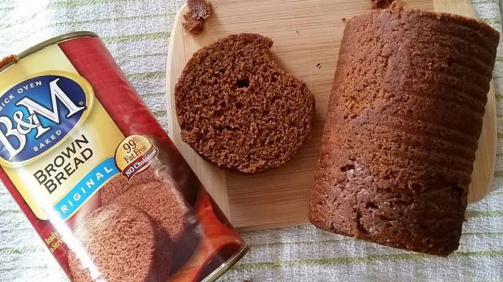 Can of brown bread and bread on cutting board