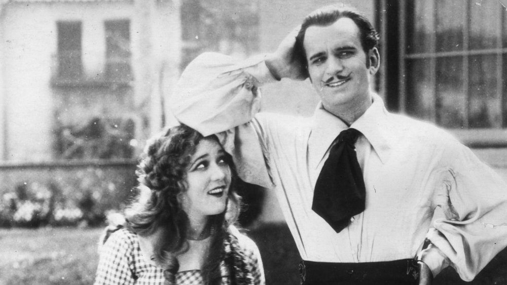 Douglas Fairbanks and Mary Pickford smiling in black and white photo