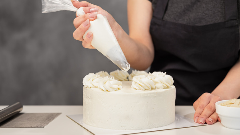 Squeezing frosting onto wedding cake