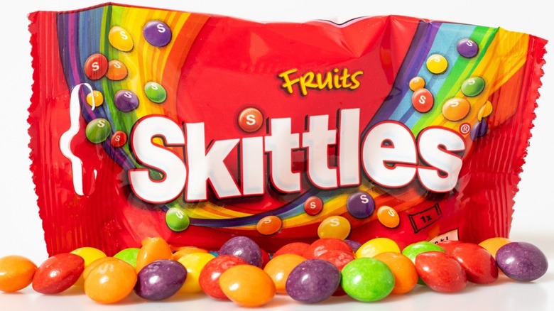 Bag of Skittles with candies scattered in front