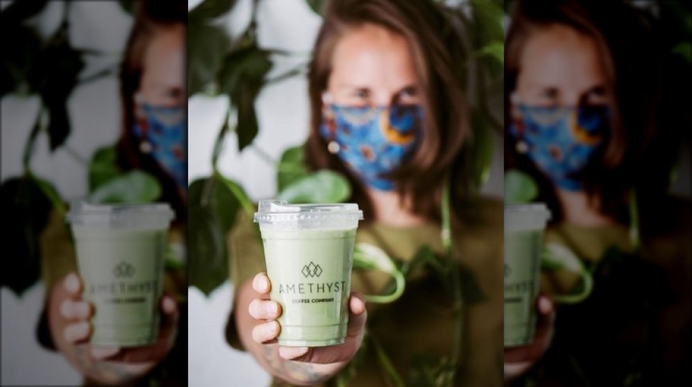 Amethyst employee holding a matcha latte