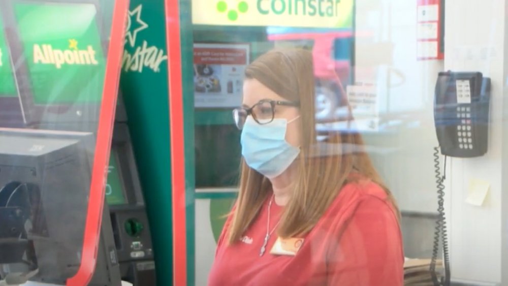 Cashier behind plexiglass shield