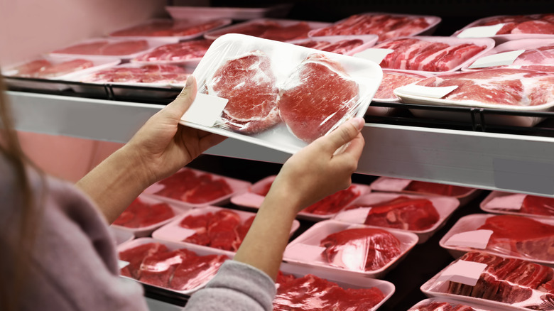 Shopper selecting meat at a supermarket