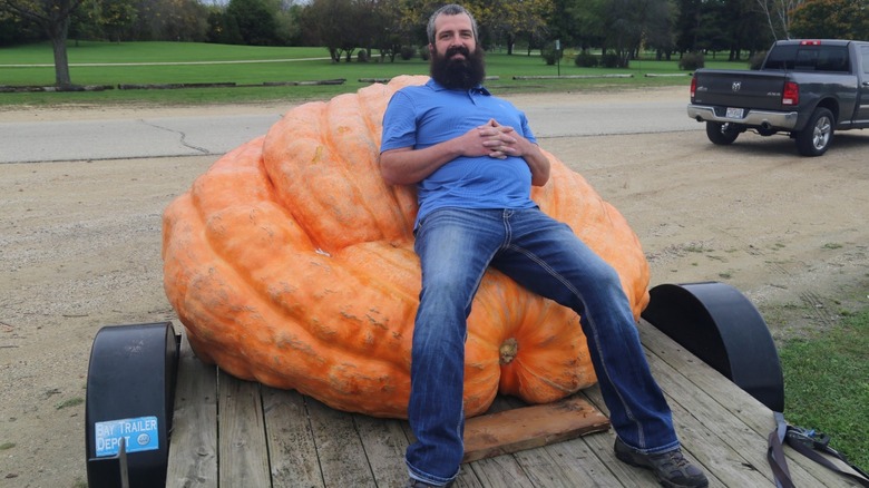 Mike Schmit resting on his oversized pumpkin