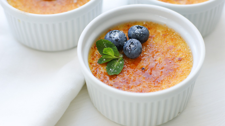 creme brulee in white ramekin topped with blueberries and mint