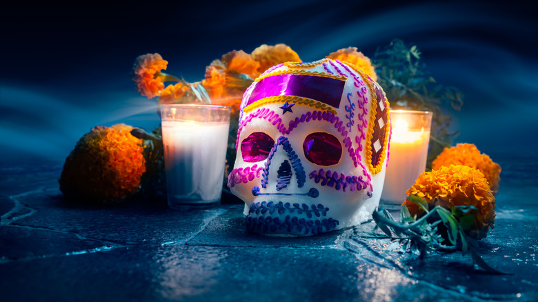 Sugar skull next to candles