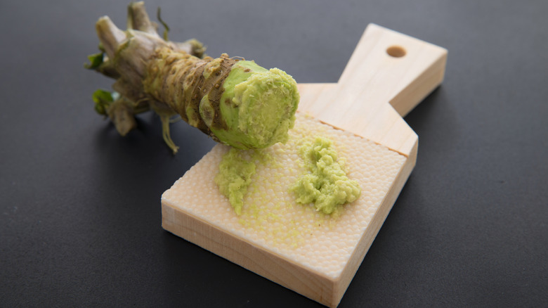 Wasabi root being ground on a wooden board