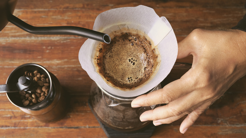 Barista pouring hot water in coffee