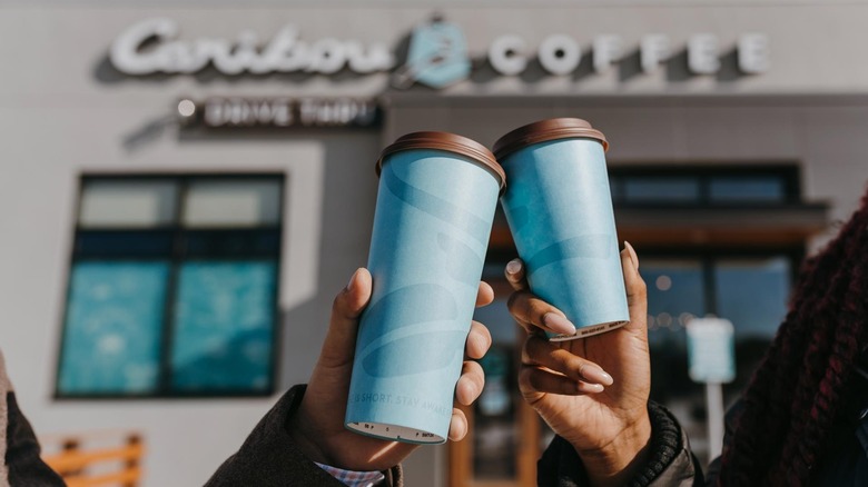 People holding Caribou Coffee outside store