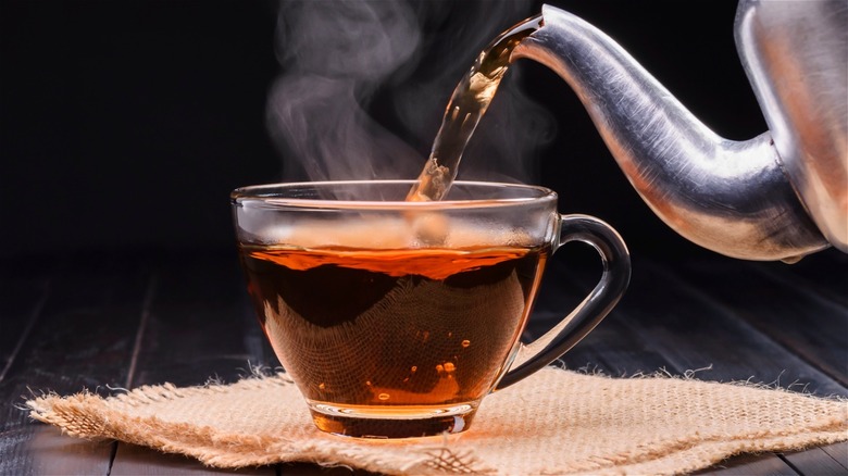 pouring tea into glass mug