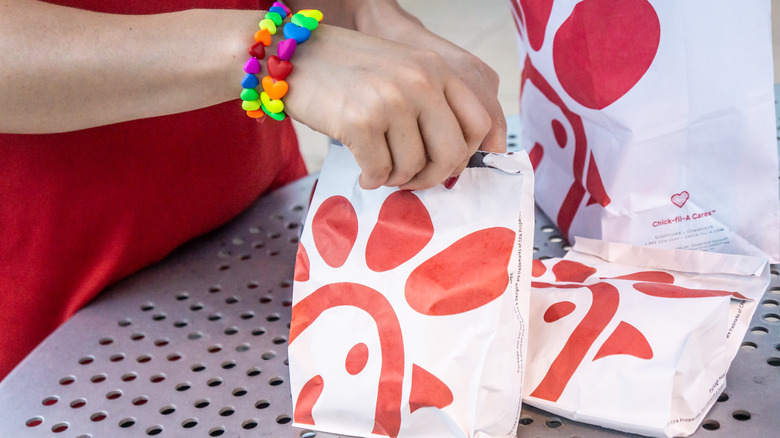 Chick-fil-A employee holding sandwich bag 