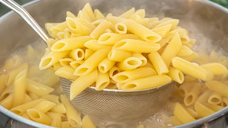 Penne pasta being boiled in a pan