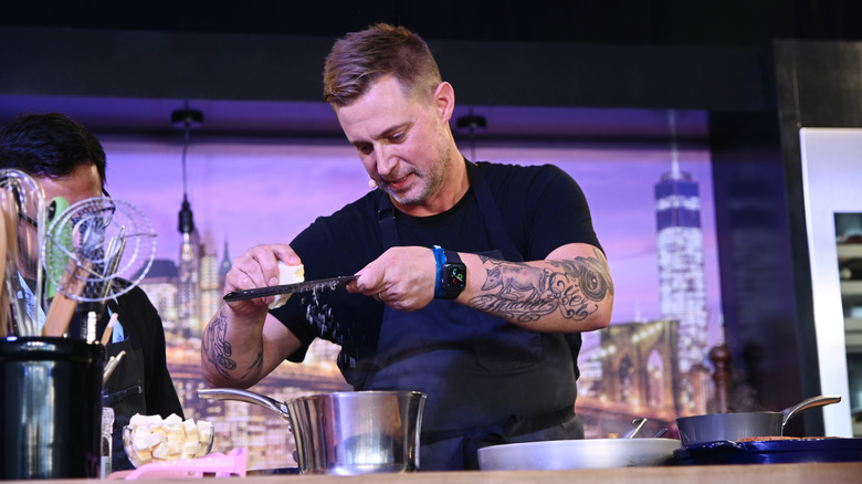 Bryan Voltaggio grating cheese onstage during an event.