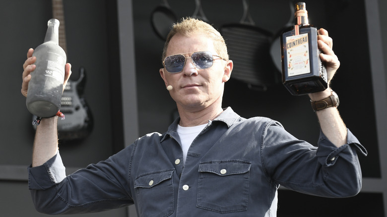 Bobby Flay at cooking demonstration holding bottles