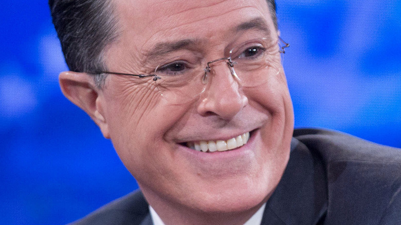 Stephen Colbert smiling and looking to the side