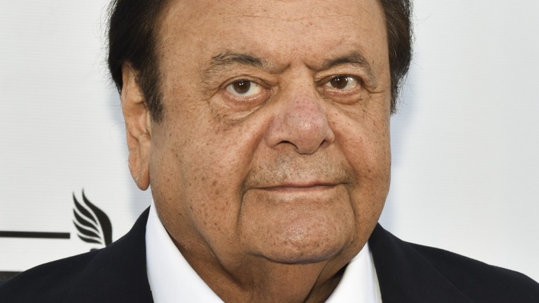Paul Sorvino with serious expression wearing suit