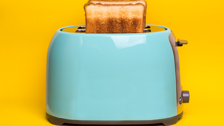 Light blue toaster with cooked pieces of toast