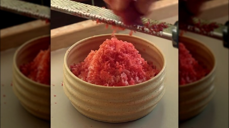 Grating frozen strawberry into bowl