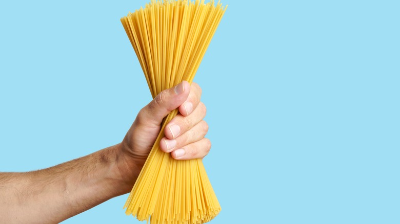A hand holding spaghetti