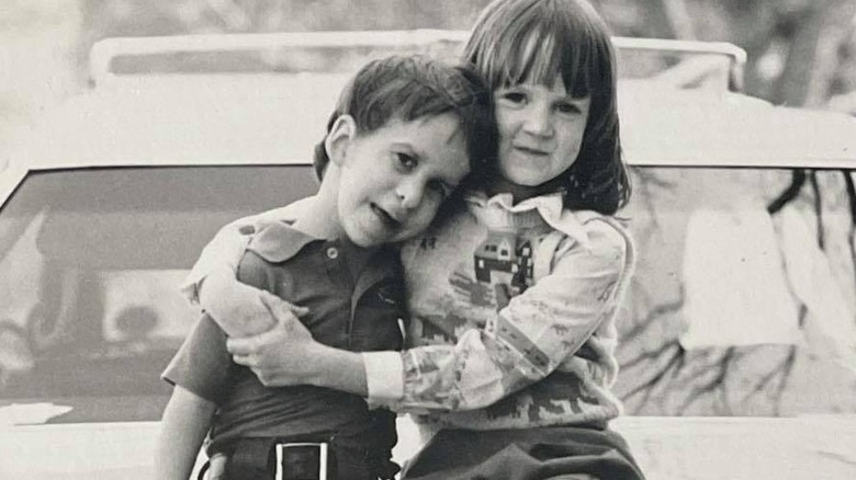 Young Ree Drummond poses with her brother on hood of car