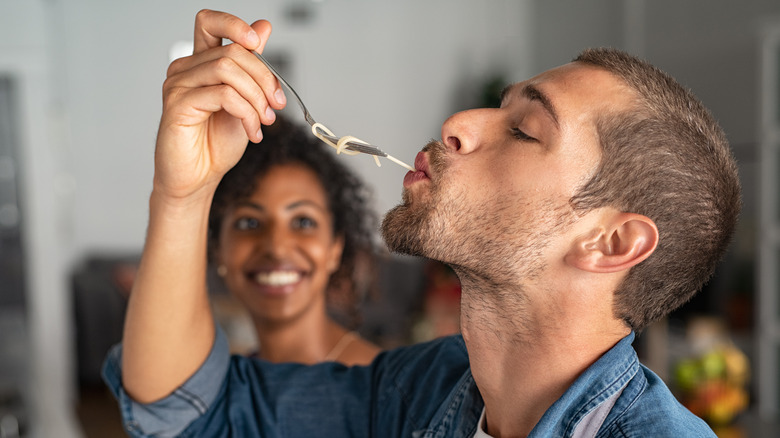 Man eating pasta off a fork