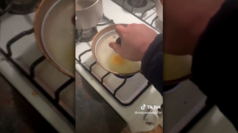 Person frying eggs with lid
