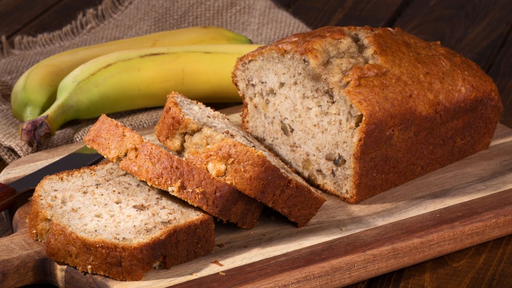 loaf of banana bread with fresh bananas next to it