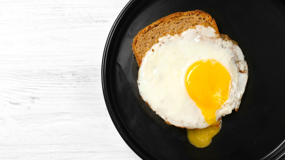 Over easy egg on toast on a plate 