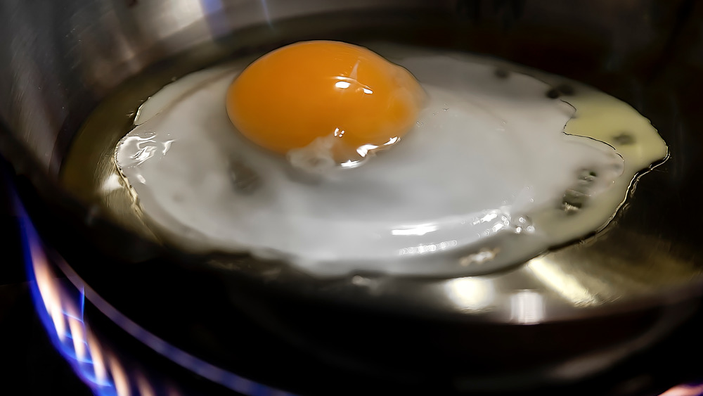 Egg cooking in oil in skillet