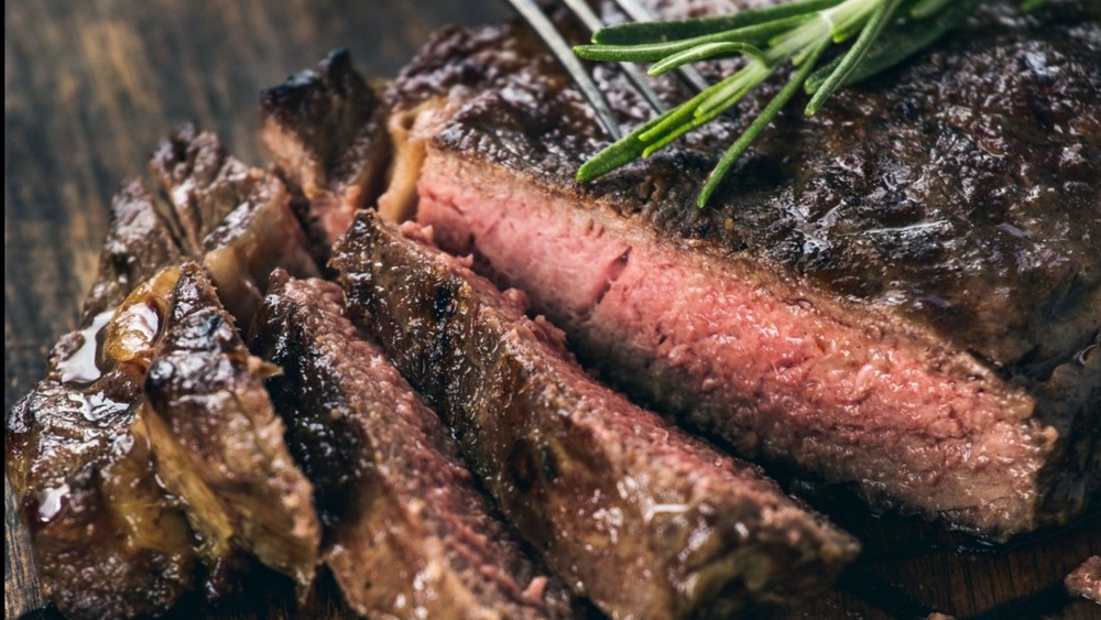 Sliced steak garnished with rosemary