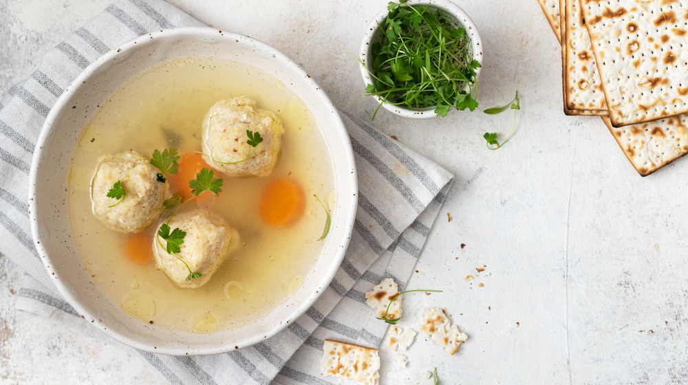 Matzo ball soup in a white bowl