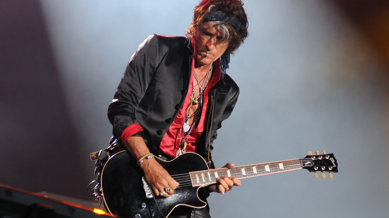 Joe Perry playing guitar on stage