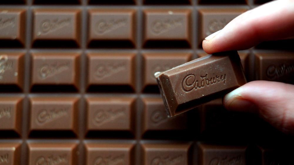 Person holding a square of Cadbury chocolate