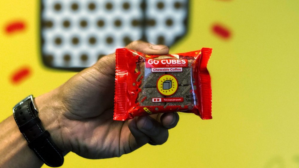 A hand holding a package of Go Cubes