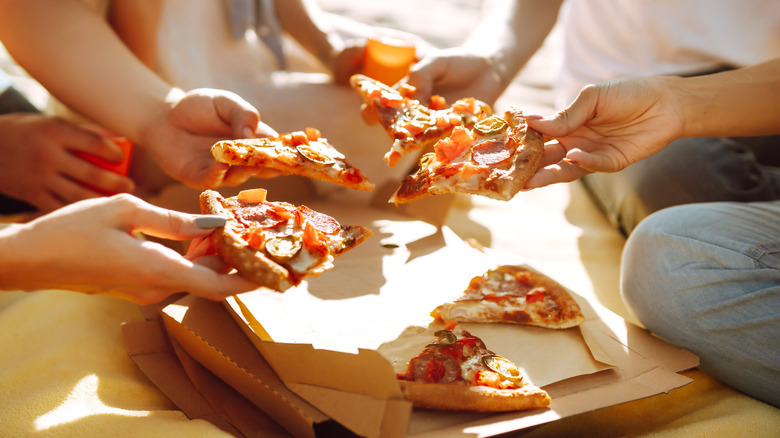 group of people sharing a pizza pie