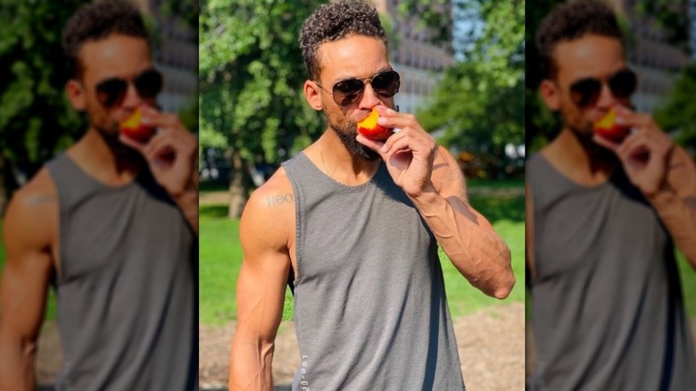 Dustin Hogue in tank top eating peach