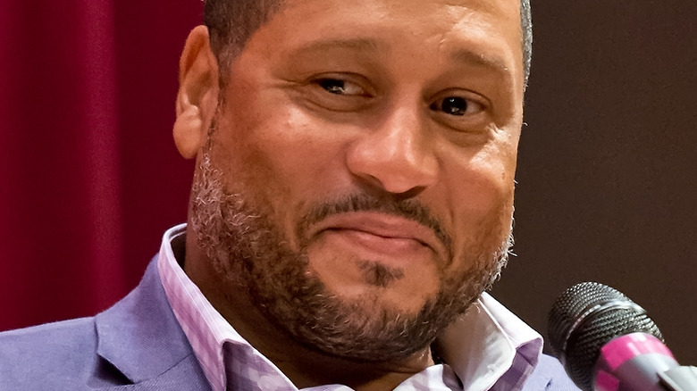 Pat Neely with slight frown seated in front of microphone