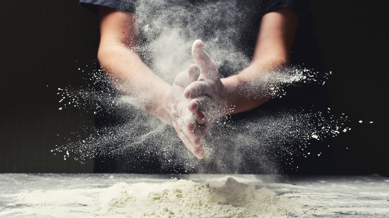 Person preparing flour for dough